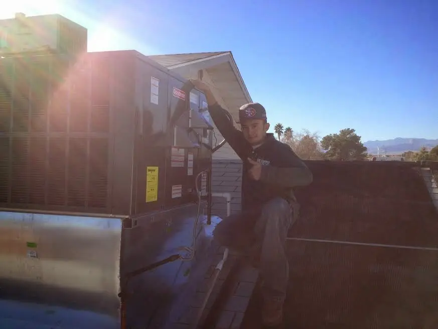 HVAC technician performing AC Tune-Up on a rooftop unit in Makakilo